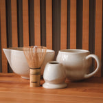 Bambu whisk, stoneware sürahi ve kupalarla birlikte masada